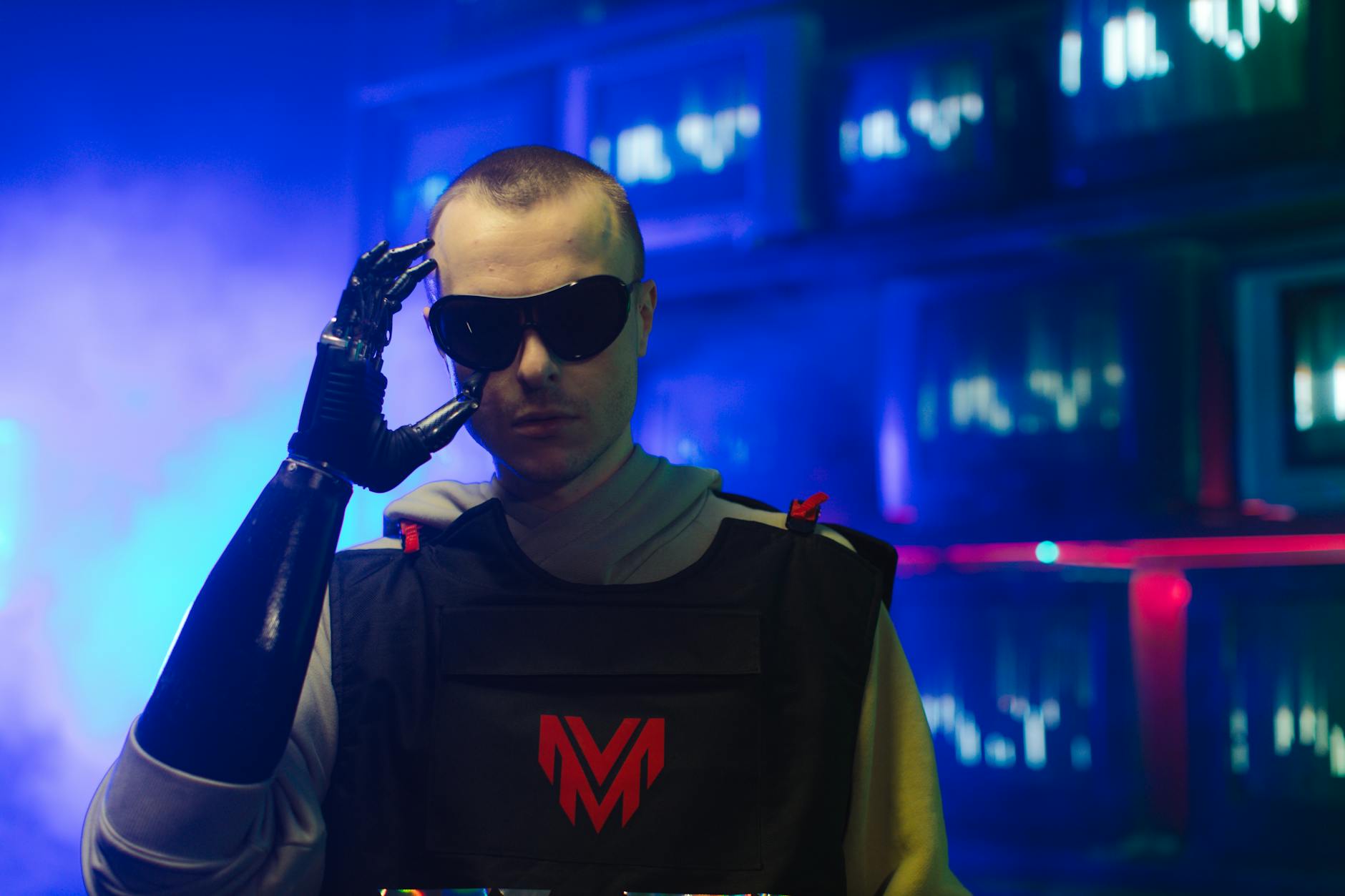 hard techno ewolucja - Portrait of an individual in futuristic gear, featuring a prosthetic arm and sunglasses.