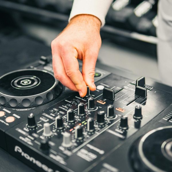 Windows 11 kontrolery DJ problem - Close-up of a DJ's hand adjusting a mixer at a live music event, showcasing professional s