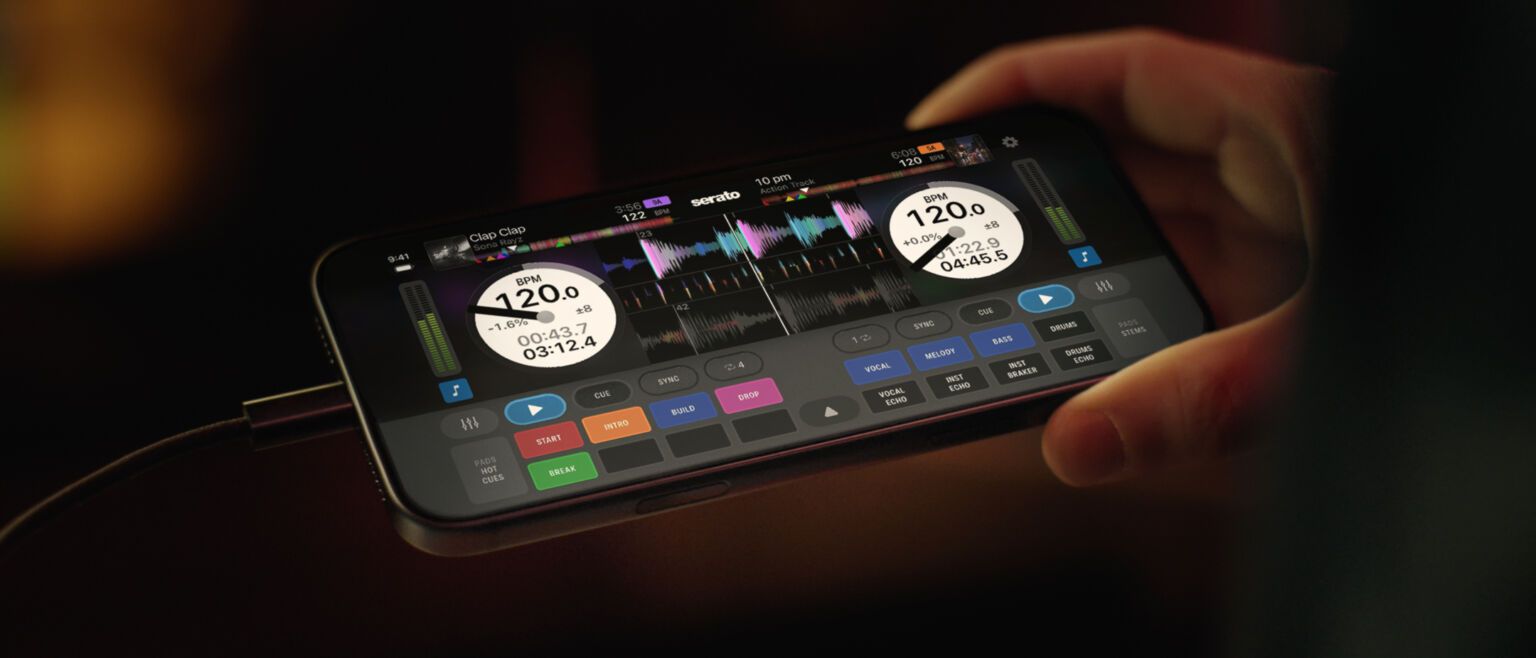 Telefon trzymany w dłoniach z otwartą aplikacją Serato DJ for iOS