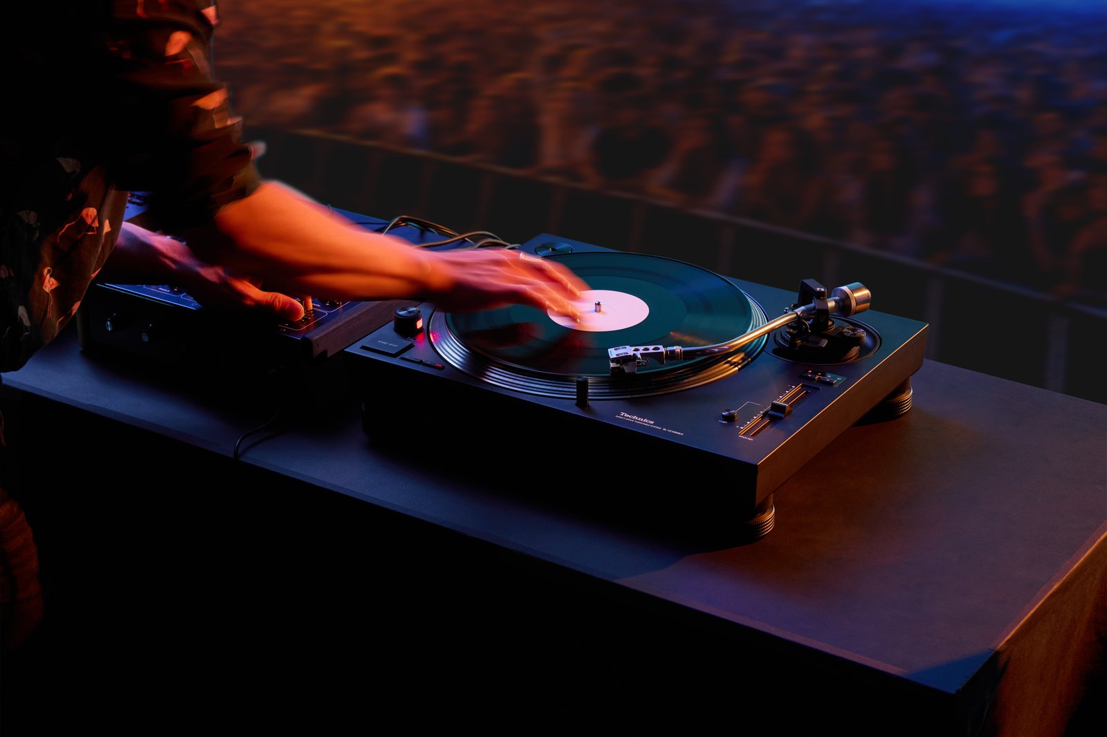 Gramofon Technics SL-1210MKX podczas scratchu w niebiesko-pomarańczowym świetle